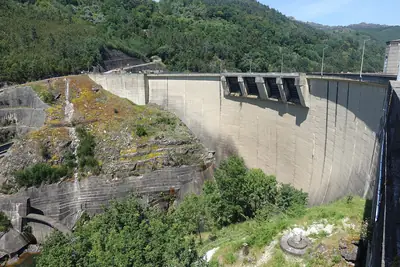 Barragem de Salamonde, em Vieira do Minho, com a parede curva de betão entre encostas verdes