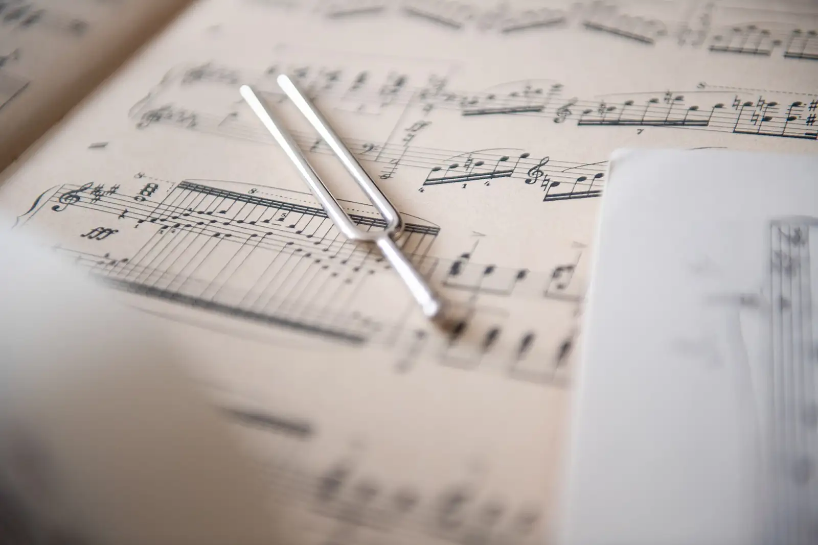 Diapasão metálico pousado sobre uma partitura